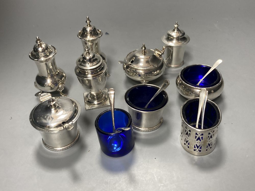 A George V silver three piece condiment set, London, 1923, a pair of silver pepperettes & four other silver condiments.